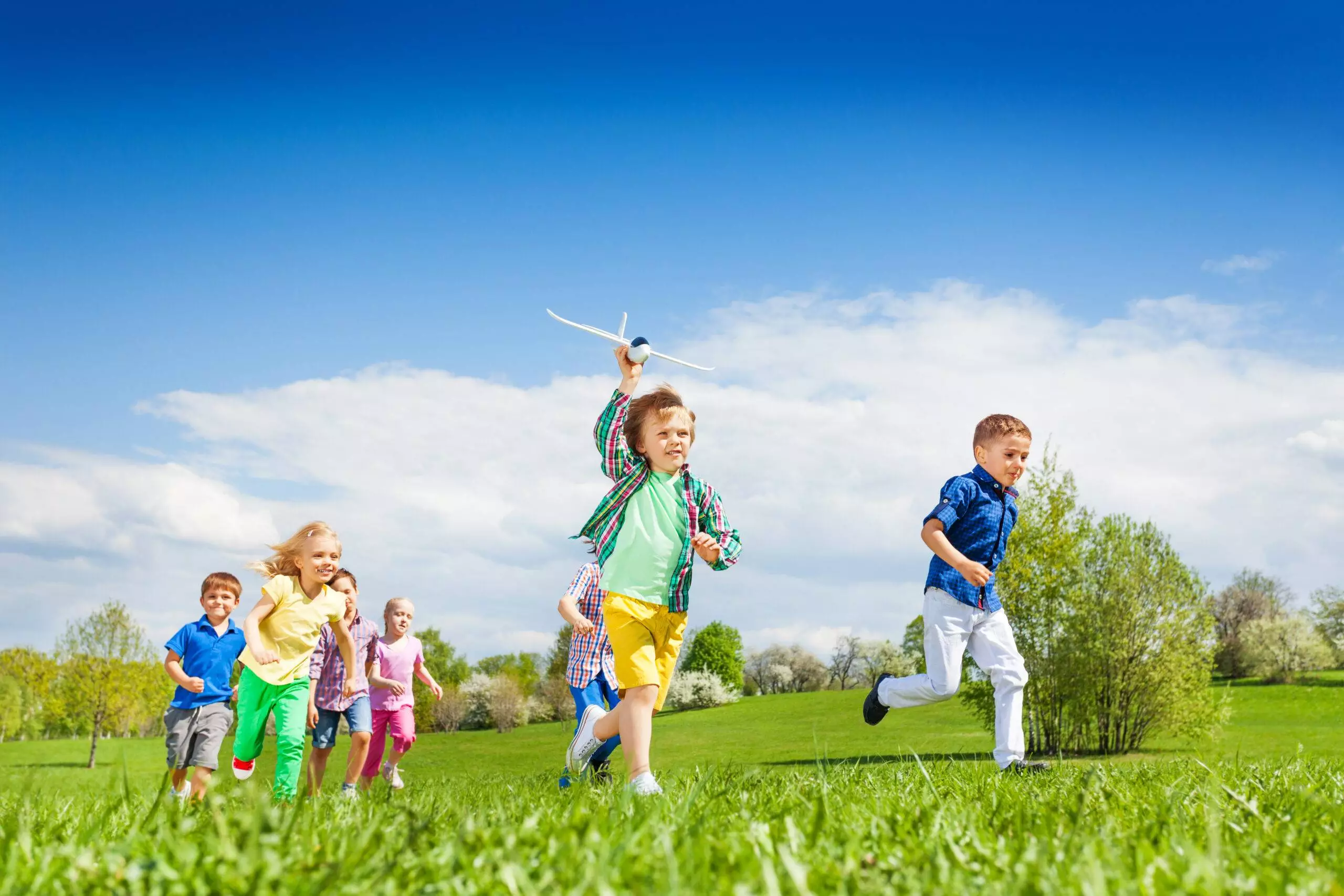 Kinder spielen gemeinsam mit einem Spielzeugflugzeug